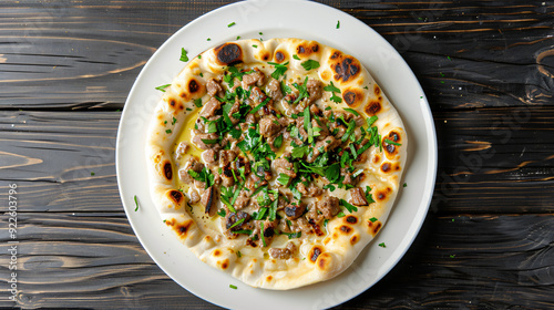 Serving a classic arabic meat and herb dish on pita bread, presented on a rustic wooden table