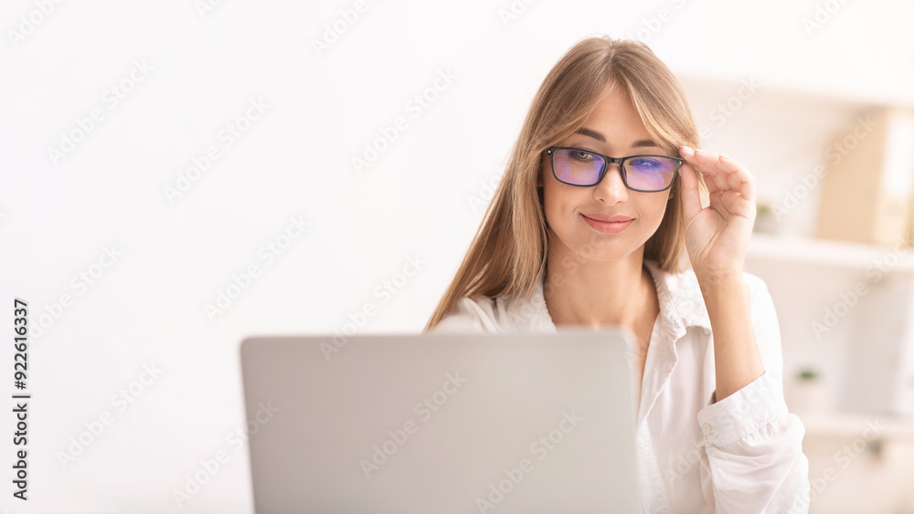 Computer Eyeglasses. Woman Using Laptop In Eyewear Working In Modern Office. Selective Focus Computer Eyeglasses. Woman Using Laptop In Eyewear Working In Modern Office. Selective Focus