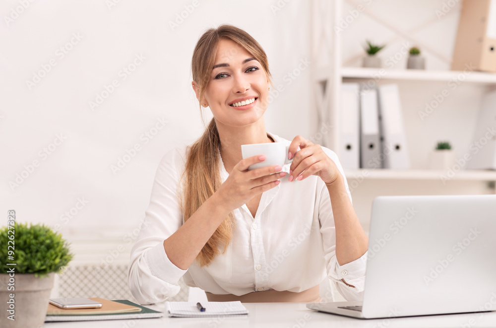 Successful Entrepreneur. Business Woman Holding Coffee Cup Smiling At Camera Sitting At Workplace In Modern Office. Successful Entrepreneur. Business Woman Holding Coffee Cup Smiling At Camera Sitting At Workplace In Modern Office.
