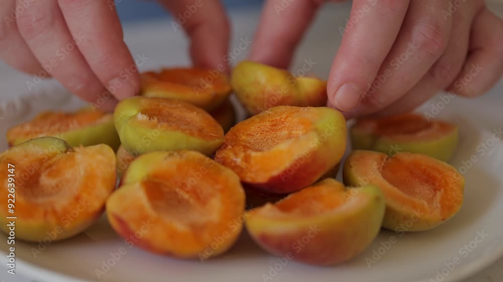 Women's hands peel fresh apricots from pits. Preparation of apricots for jam. Women's hands peel fresh apricots from pits. Preparation of apricots for jam.
