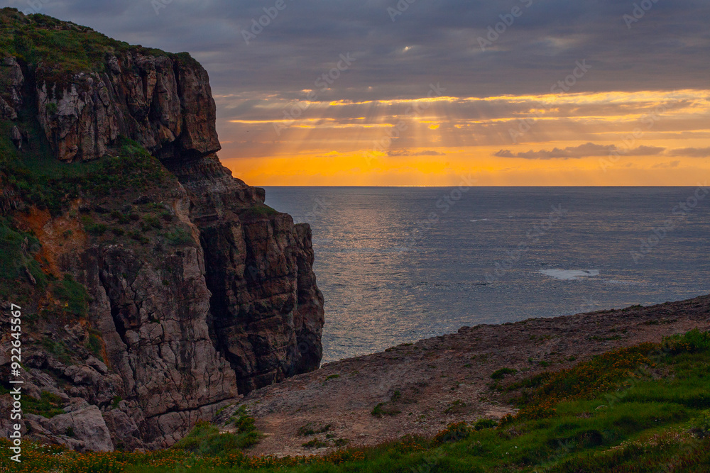 Sunset with beautiful clouds and rays on the Atlantic seacost in Cantabria, spain