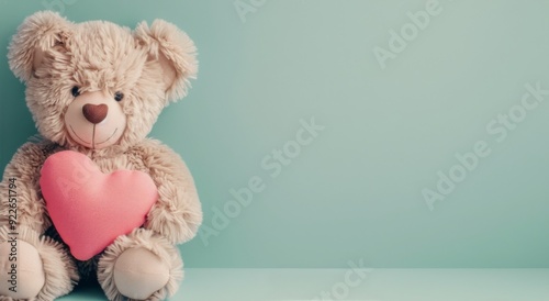 Adorable Teddy Bear Holding Pink Heart Against Soft Blue Background