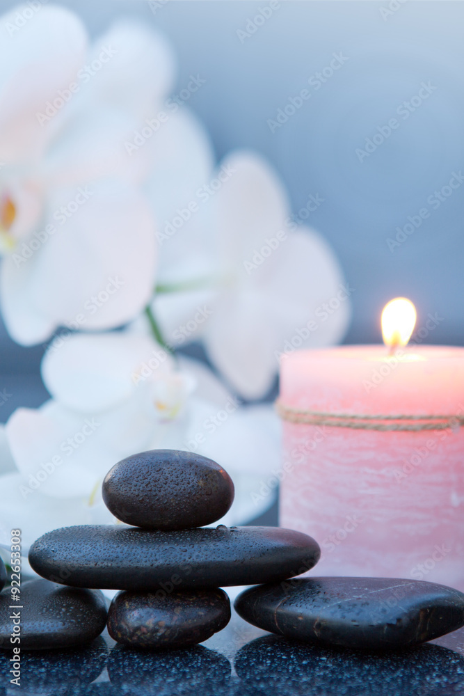 Obraz premium Spa background with white orchid , candle and zen black stones on gray.