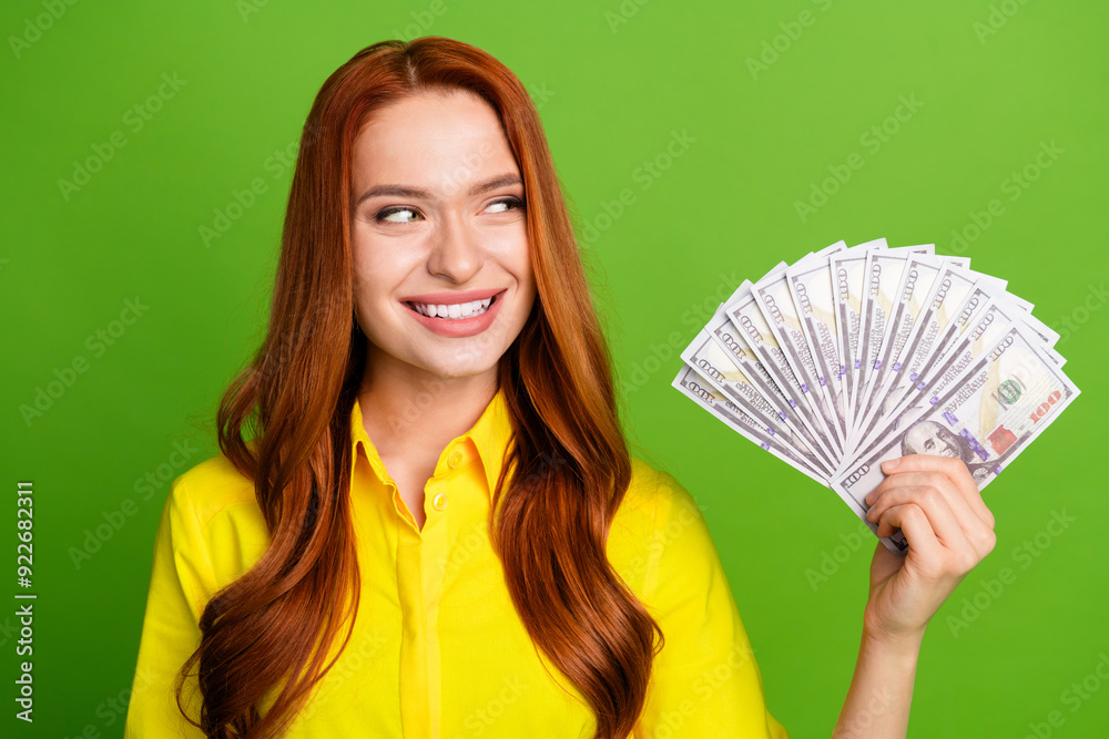 Photo of cheerful lovely cute woman wear yellow trendy clothes look cash isolated on green color background Photo of cheerful lovely cute woman wear yellow trendy clothes look cash isolated on green color background