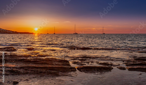 Sailboat moored in the bay of Barcaggio at sunset, Corsica, France. Beautifull sunset in Corsica. .Summer evening on a beach, Mediterranean sea, France. photo