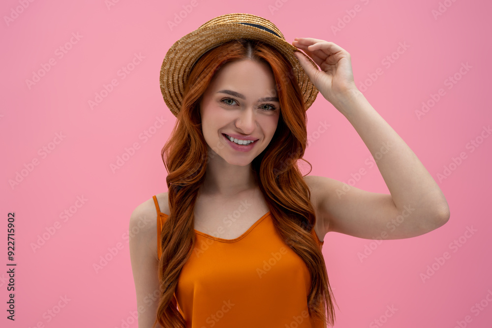 Pretty flirty young woman in straw hat looking contented