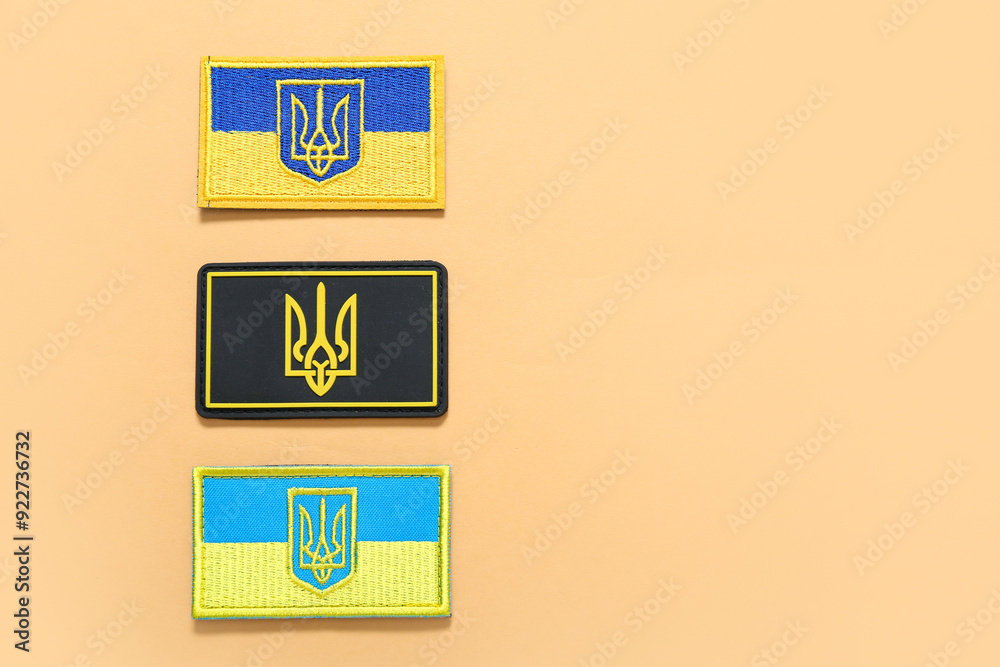 Different military badges of Ukrainian army with trident on beige background Different military badges of Ukrainian army with trident on beige background