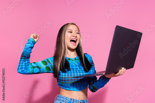 Photo of adorable lucky girl wear print top winnin game modern gadget empty space isolated pink color background photo