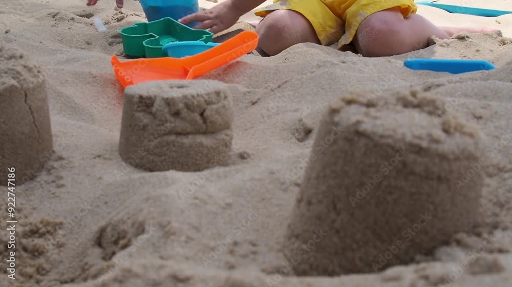 A child plays in the sand on the beach A child plays in the sand on the beach
