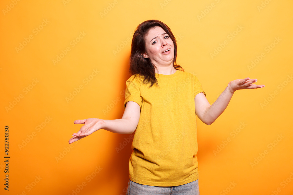 Portrait of clueless woman raising her hands and shoulders, unsure of the question. Caucasian lady with doubts is standing over isolated background with an uncertain and confused expression.