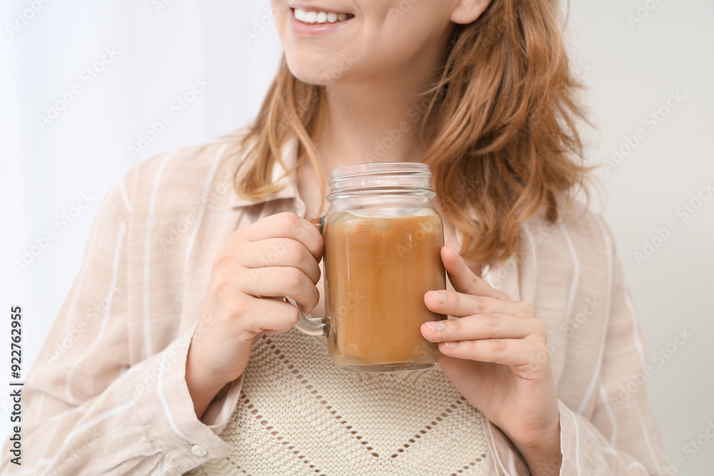 Young woman with jar mug of tasty iced latte at home, closeup Young woman with jar mug of tasty iced latte at home, closeup