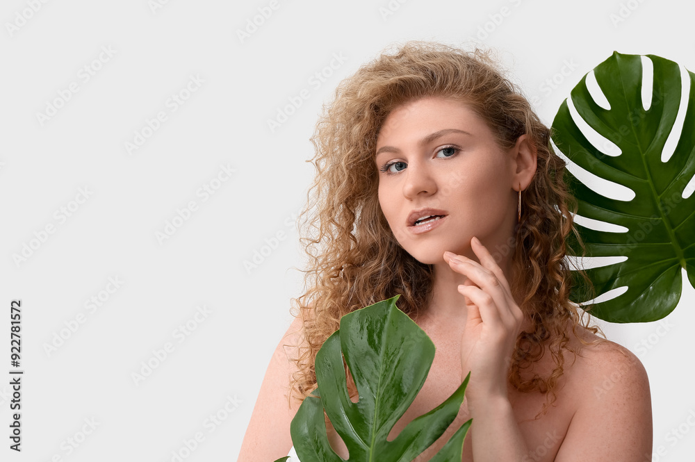 Beautiful young woman with tropical monstera leaves on white background Beautiful young woman with tropical monstera leaves on white background