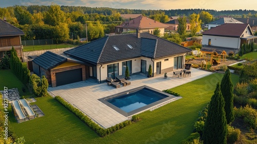 Aerial shot of a stylish modern home featuring a swimming pool, expansive patio, and meticulously landscaped garden in a peaceful suburban setting.
