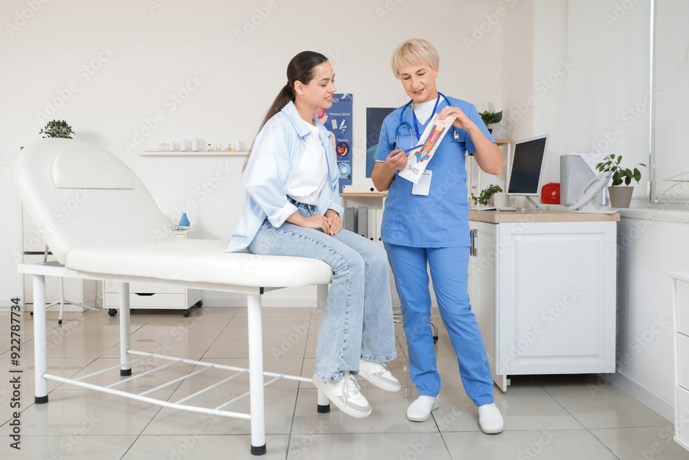 Female endocrinologist showing structure of thyroid gland to patient in clinic Female endocrinologist showing structure of thyroid gland to patient in clinic