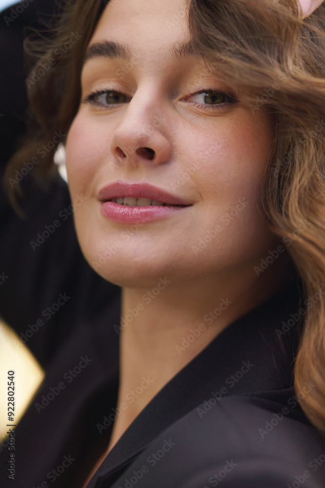 Close-up of a confident woman with a gentle smile, wearing a black blazer, showcasing natural beauty. Close-up of a confident woman with a gentle smile, wearing a black blazer, showcasing natural beauty.