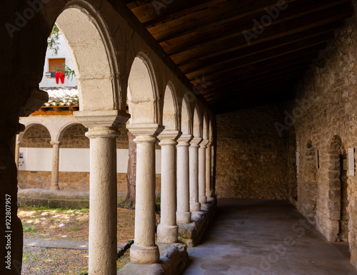 Scenic view of ancient covered walkways with rounded arches supported by stone columns surrounding cloister of Monastery of Sant Llorenc de Morunys in province of Lleida, Catalonia, Spain photo