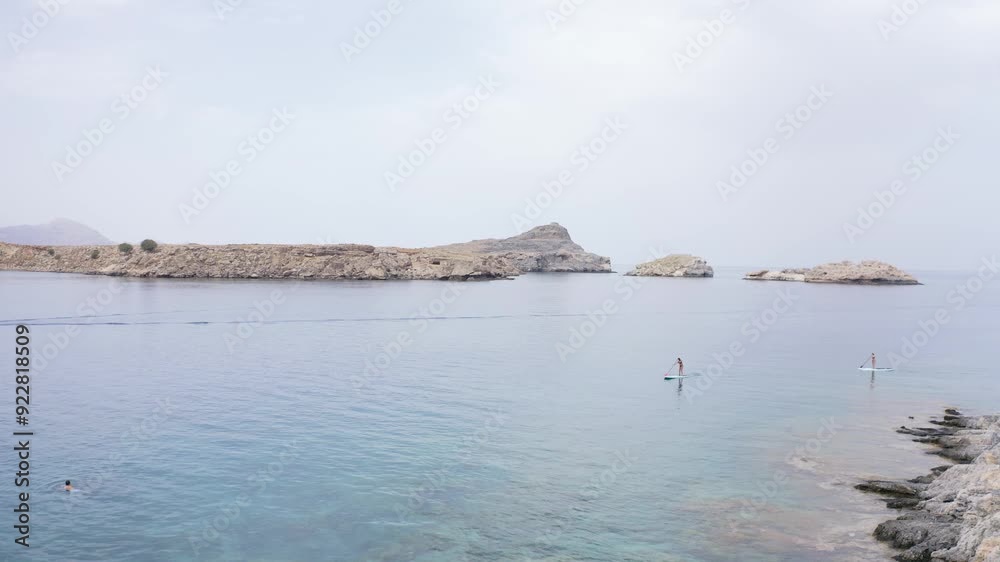 4K Aerial Video of Stand Up Paddle Boarder Girls at Greek Island Coastline. 4K Aerial Video of Stand Up Paddle Boarder Girls at Greek Island Coastline.