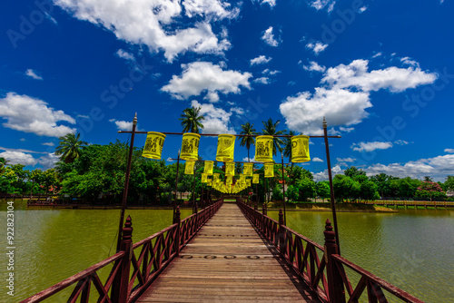 Background of Wat Traphang Thong, which is located in the middle of the water and has a wooden bridge, which is used to organize ceremonies (Loi Krathong, New Year) in Sukhothai province, Thailand. photo