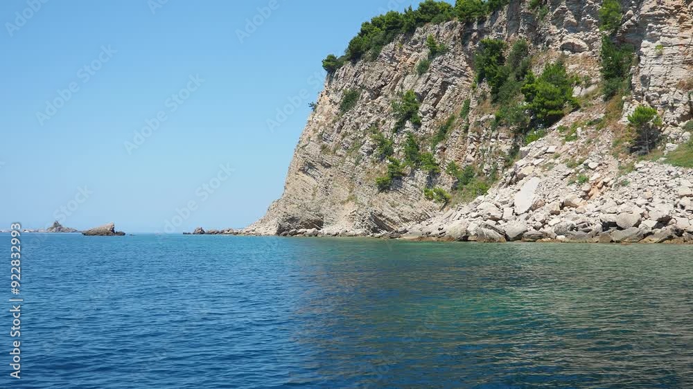 Nature park Katic between Buljarica and Petrovac, Budva district, Montenegro. Adriatic coast Mediterranean. Otocic Vatulja Vyhlidka beach. Boat trip along waves with view of volcanic mountains and sea Nature park Katic between Buljarica and Petrovac, Budva district, Montenegro. Adriatic coast Mediterranean. Otocic Vatulja Vyhlidka beach. Boat trip along waves with view of volcanic mountains and sea