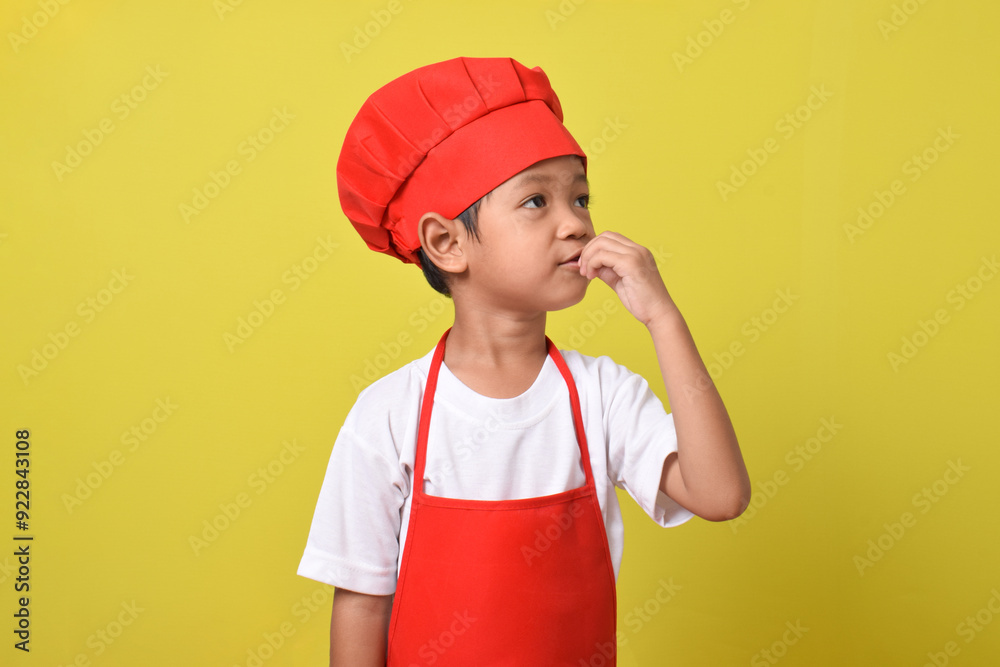 Cute little chef showing perfect sign isolated on yellow background. Asian boy wearing red apron and hat Cute little chef showing perfect sign isolated on yellow background. Asian boy wearing red apron and hat