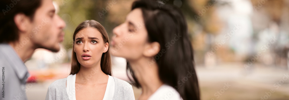 Fototapeta premium Infidelity. Girl Looking At Her Cheating Boyfriend Kissing Dating With Other Woman In Park Outdoors. Selective Focus