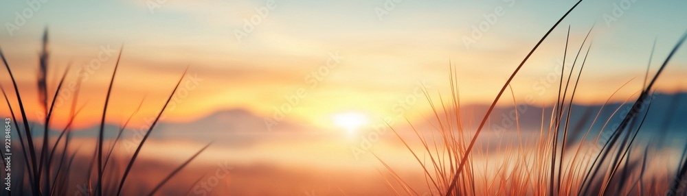 A serene sunset over mountains, with vibrant colors blending in the sky and gently swaying grass in the foreground. A serene sunset over mountains, with vibrant colors blending in the sky and gently swaying grass in the foreground.