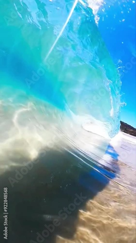 Crystal clear turquoise open ocean sea underwater footage. Waves breaks over camera on shallow sand beach. photo