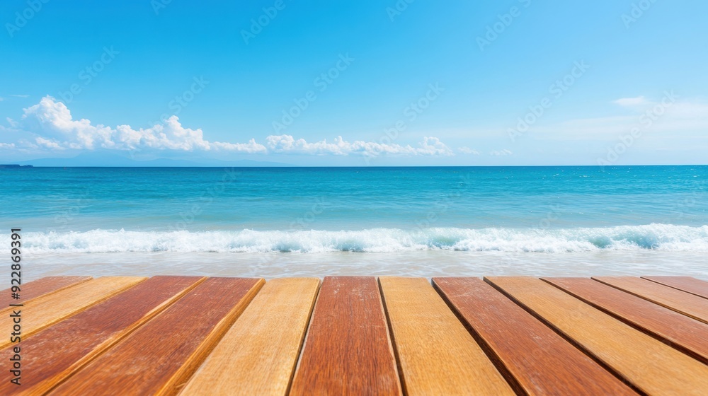 A wooden table overlooks the beach as gentle waves wash ashore under a clear sky A wooden table overlooks the beach as gentle waves wash ashore under a clear sky