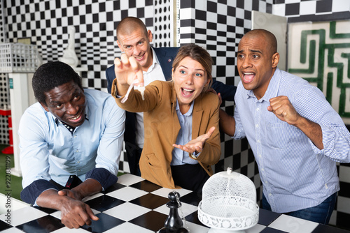 Young adult people trying to solve puzzles to get out of escape room photo