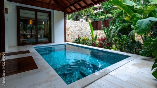 A serene outdoor spa with a private plunge pool, surrounded by tropical plants and flowers.