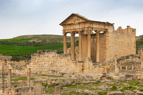 Ruins of ancient Roman capitol on territory of antic city of Dougga in area of modern Tunisia. Half-destroyed buildings from time of Roman Empire. photo