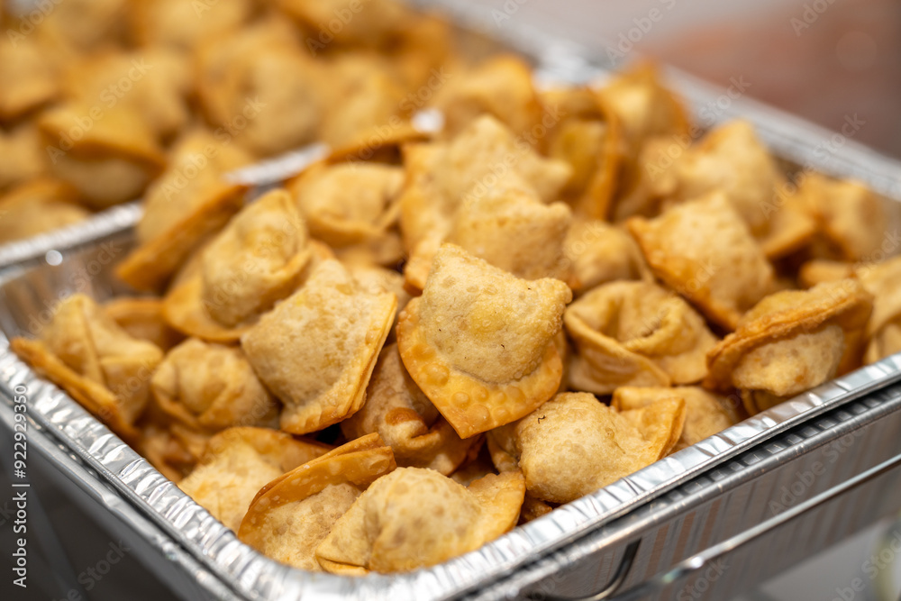 Chinese cream cheese wontons served in a silver catering container delivered for an event. Crispy crab rangoon Chinese cream cheese wontons served in a silver catering container delivered for an event. Crispy crab rangoon