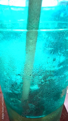 Closeup shows ice crystals forming on colorful plastic glass