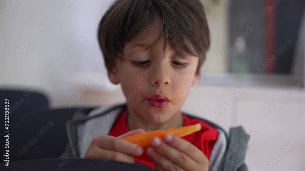 Young boy thoughtfully eating a fresh carrot, focusing on each bite, highlighting healthy eating habits and childhood moments in a casual home setting Young boy thoughtfully eating a fresh carrot, focusing on each bite, highlighting healthy eating habits and childhood moments in a casual home setting
