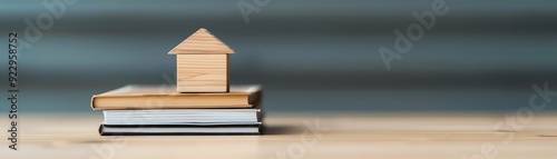 Wooden house model on a stack of books, concept of home education.