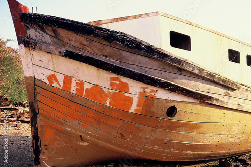 Old wooden fishing boat washed up and abandoned on the beach