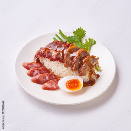 Red pork and crispy pork rice with Chinese sausage and egg on a white plate.