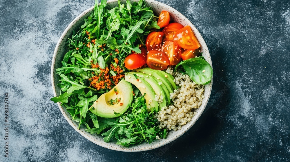 Fresh and Healthy Vegan Salad Bowl with Avocado, Quinoa, Cherry Tomatoes, and Mixed Greens on Dark Background Fresh and Healthy Vegan Salad Bowl with Avocado, Quinoa, Cherry Tomatoes, and Mixed Greens on Dark Background