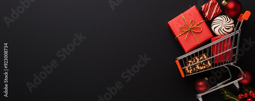Holiday shopping cart with festive gifts on black background photo