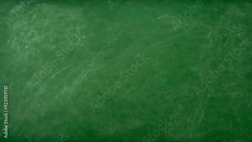 A detailed texture of a green school chalkboard with visible chalk marks and scratches. The surface appears slightly worn and matte, reflecting light subtly, ideal for backgrounds or educational theme