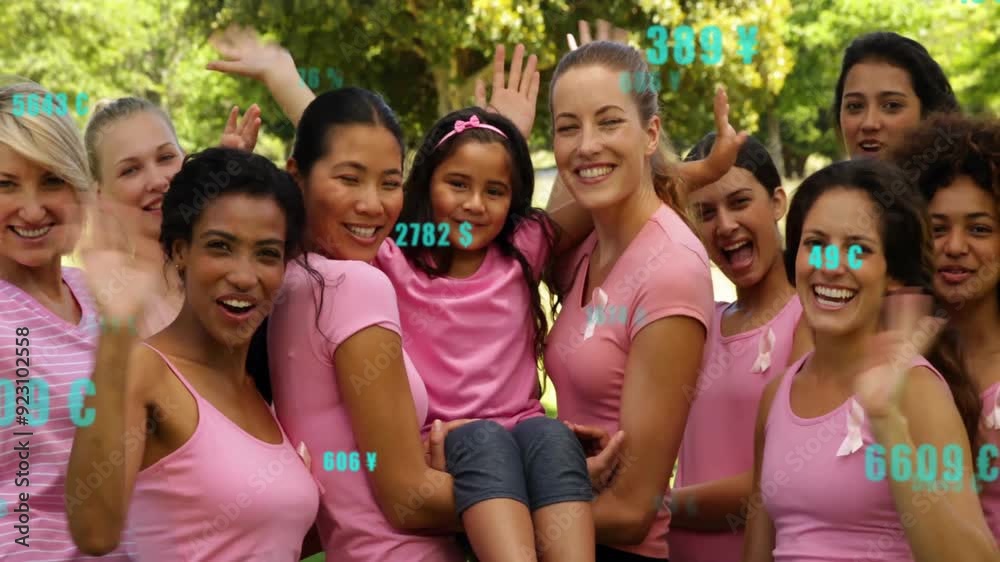 Group of women in pink shirts celebrating with numbers animation over them Group of women in pink shirts celebrating with numbers animation over them