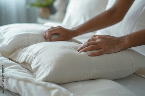 Close-up of a hand resting on a white pillow, creating a serene and relaxing atmosphere.