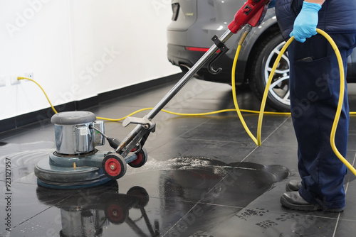 Close-up shot a worker washing office floor with cleaning machine