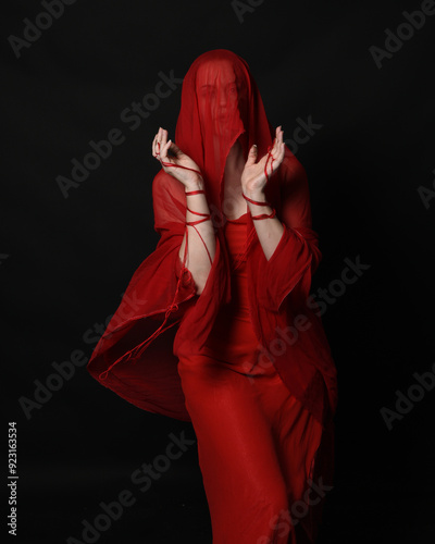 Fotografie close up portrait of beautiful female model wearing a veil head covering like blindfold and red dress