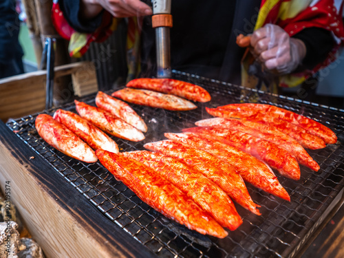 Photos Freshly grilled crab sticks sizzle on a barbecue, their vibrant red surfaces charring slightly