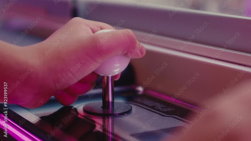 close up of young kid controlling a joystick while playing arcade video game close up of young kid controlling a joystick while playing arcade video game