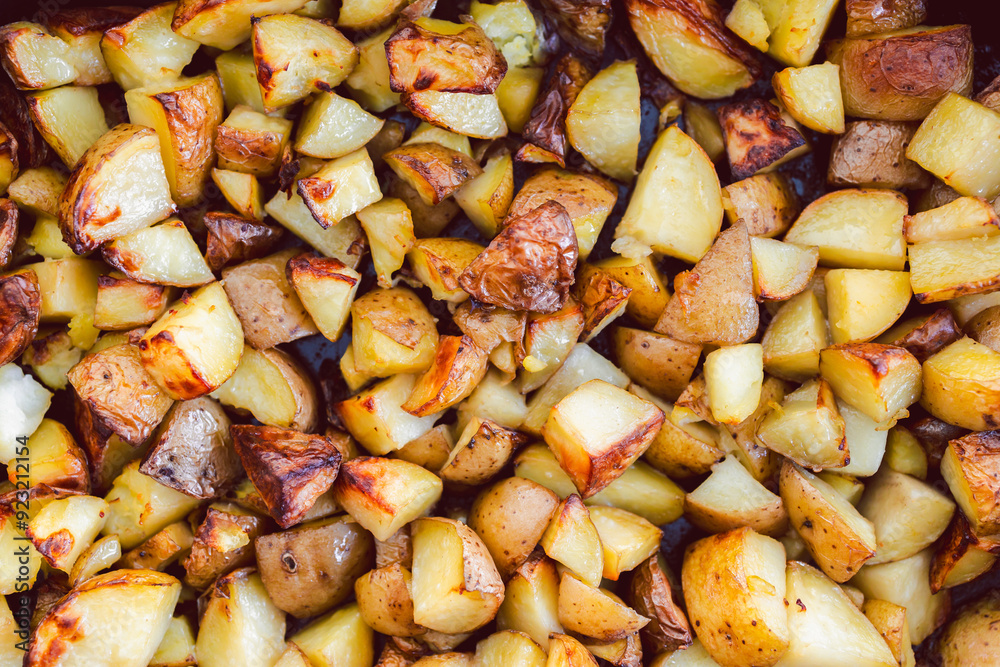 chopped roasted potatoes in cast iron oven tray chopped roasted potatoes in cast iron oven tray