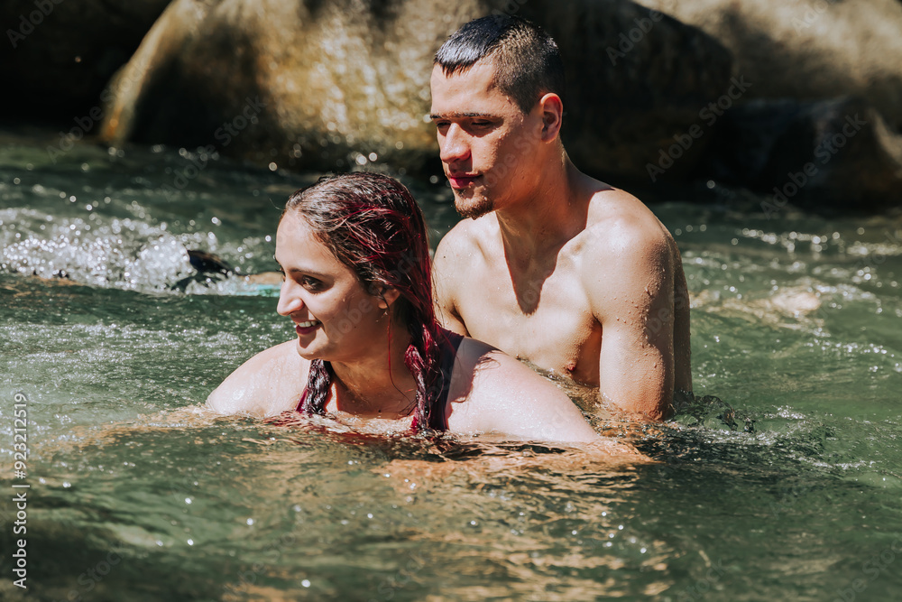 Couple in love in the water, enjoying their trip to a Colombian village. People smiling. Rivers and waterfalls. Couple in love in the water, enjoying their trip to a Colombian village. People smiling. Rivers and waterfalls.
