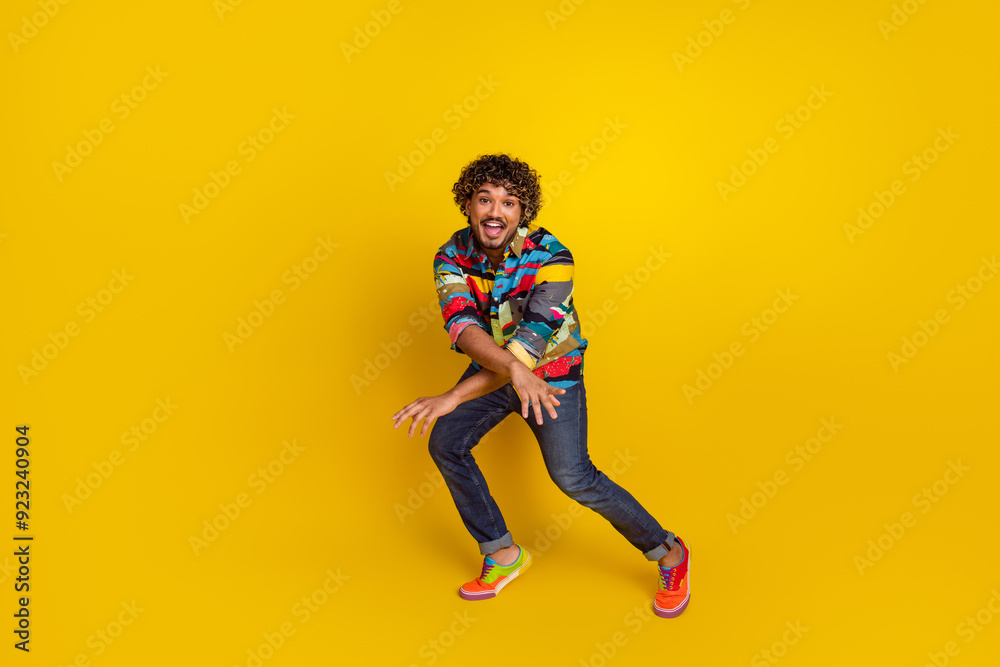 Full length photo of handsome young male dancing enjoy disco dressed stylish colorful garment isolated on yellow color background Full length photo of handsome young male dancing enjoy disco dressed stylish colorful garment isolated on yellow color background