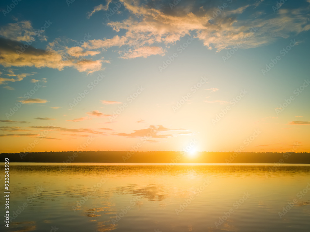 Sunrise or sunset on a lake or river with dramatic cloudy sky reflection in the water in summer. Sunrise or sunset on a lake or river with dramatic cloudy sky reflection in the water in summer.